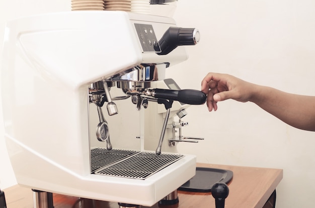 Mão segurando a máquina de café na cafeteria. conceito de cafeteria