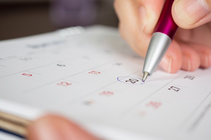 Foto mão segurando a marca do círculo da caneta na data do calendário