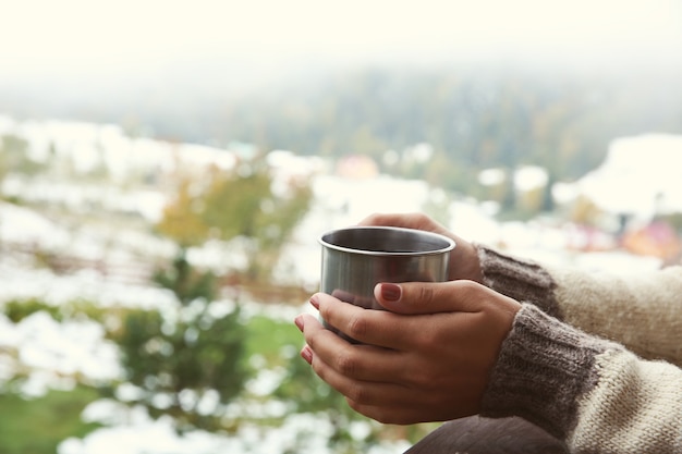 Mão segurando a xícara de café nas montanhas