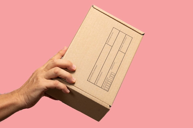 Mão segurando caixa para embalar produto a ser enviado por correio com dizeres em português