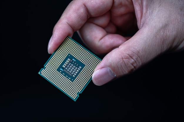 Mão segurando CPU em fundo preto