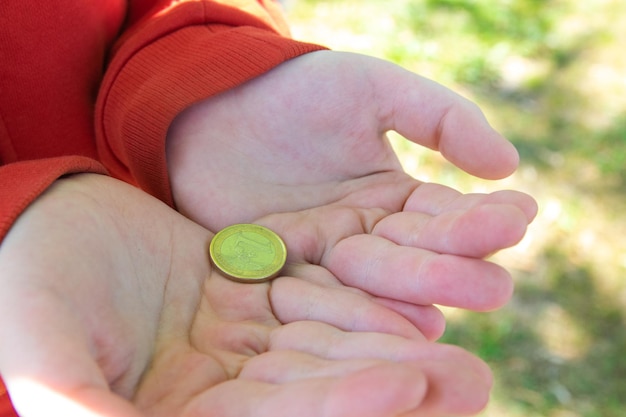 Mão segurando moedas de euro na rua