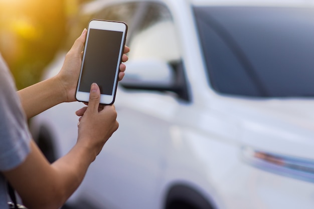 Foto mão segurando o aplicativo móvel do telefone inteligente para iniciar a tecnologia do carro vida inteligente 5g