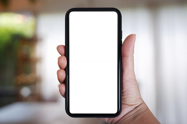 Foto mão segurando o smartphone com tela em branco para app no interior do café