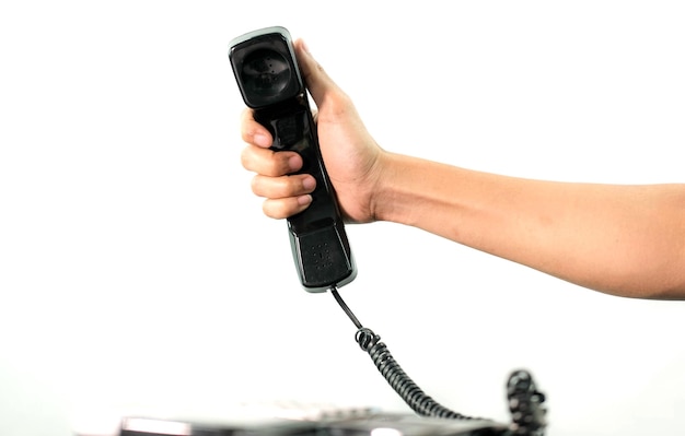 Foto mão segurando o telefone do escritório em fundo branco.