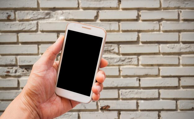 Foto mão segurando o telefone inteligente com desfoque de fundo