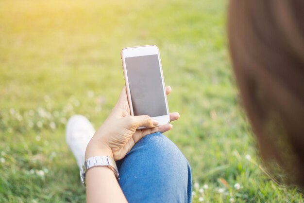 mão segurando o telefone inteligente com fundo de natureza