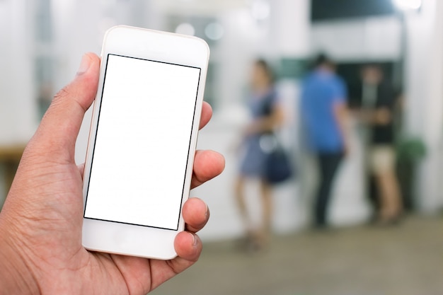 Mão segurando o telefone inteligente móvel com tela em branco na posição vertical