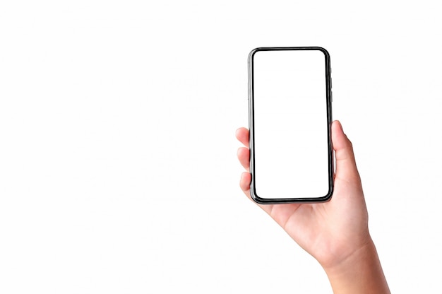 Mão segurando o telefone móvel de tela em branco, isolado na parede branca