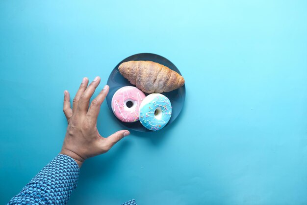 mão segurando rosquinhas frescas