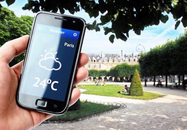 Mão segurando smartphone com clima em Paris