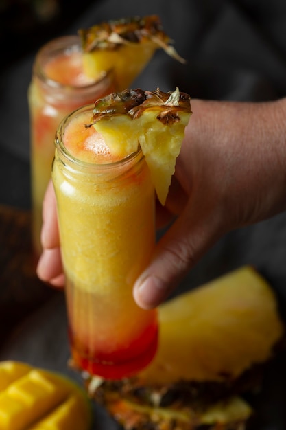 Foto mão segurando suco de frutas exóticas