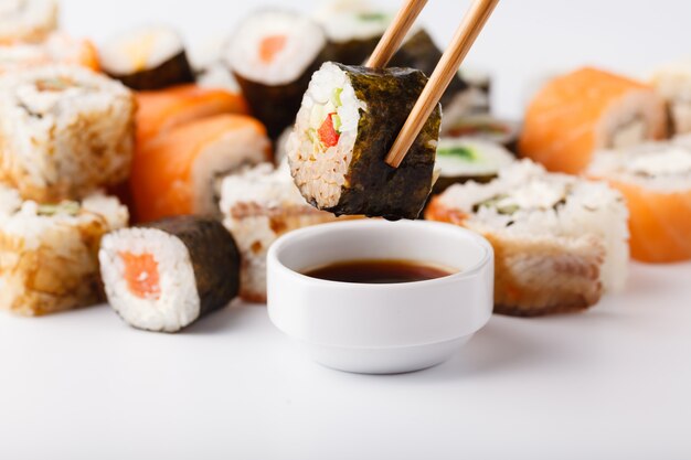 Mão segurando sushi rolo de salmão em pauzinhos com espaço de cópia para o trabalho de design