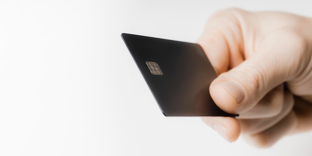 mão segurando um cartão de crédito em um fundo branco