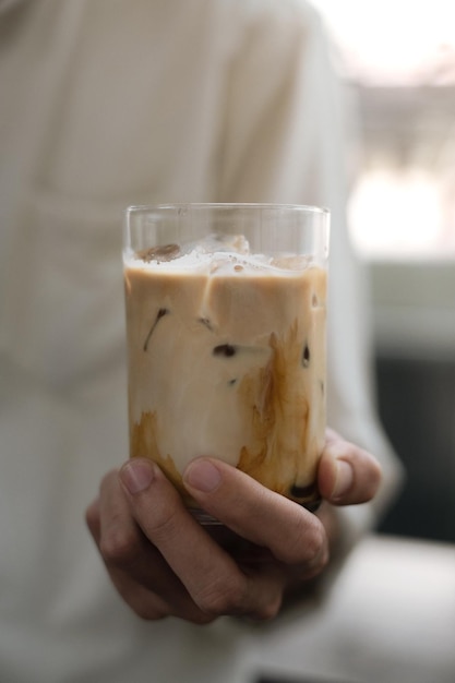 mão segurando um copo de café gelado