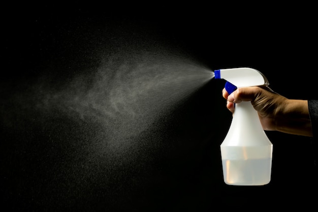 Foto mão segurando um frasco de spray desinfetante