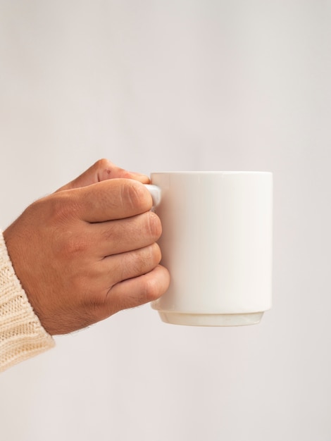 Mão segurando um modelo de caneca