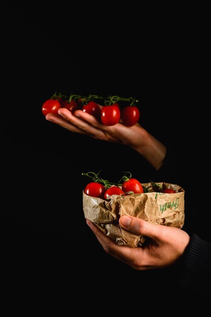 Foto mão segurando um monte de tomate cereja