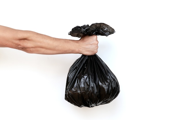 Mão segurando um saco de lixo cheio