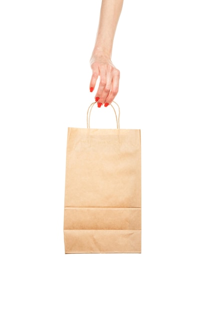 Mão segurando um saco de papel marrom com alça isolada no fundo branco