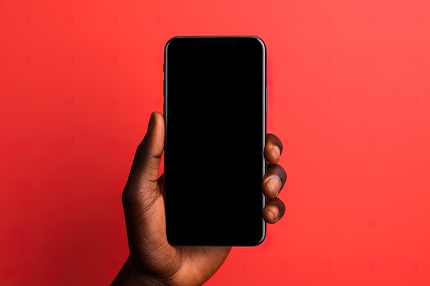 Mão segurando um smartphone com uma tela preta em branco isolada em um fundo vermelho