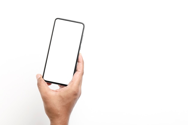 Mão segurando um smartphone em uma superfície branca.