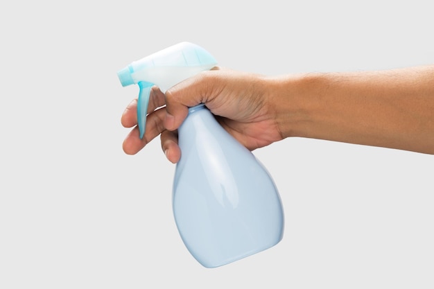 Mão segurando um spray desinfetante