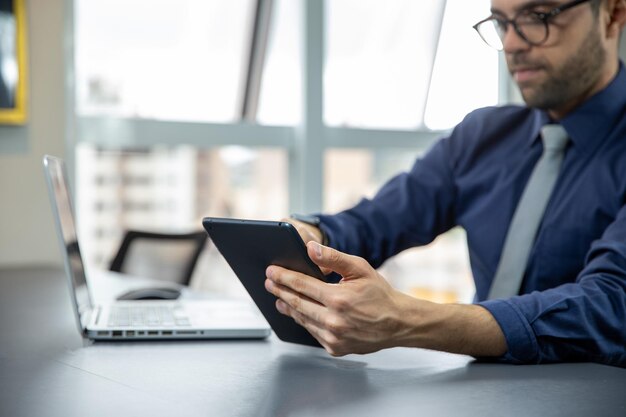 Mão segurando um tablet em primeiro plano