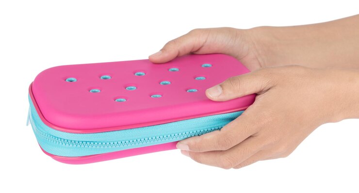 Foto mão segurando uma bolsa de lápis, estojo de caneta para meninas isolado em um fundo branco