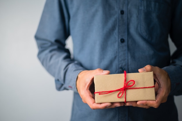 Mão segurando uma caixa de presente, caixa de presente de ano novo, caixa de presente de Natal, espaço de cópia. Natal, ano de vida, conceito de aniversário.