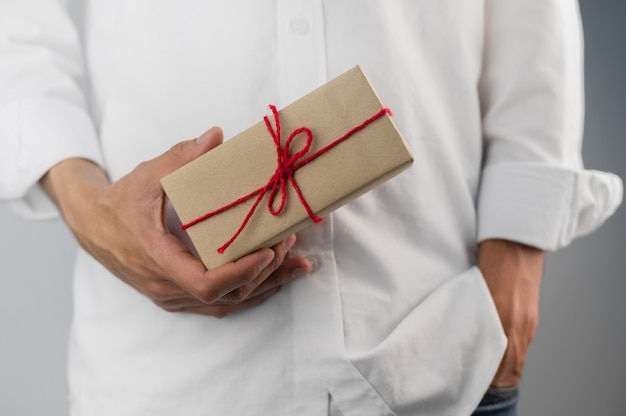 Mão segurando uma caixa de presente, caixa de presente de ano novo, caixa de presente de Natal, espaço de cópia. Natal, ano de vida, conceito de aniversário.