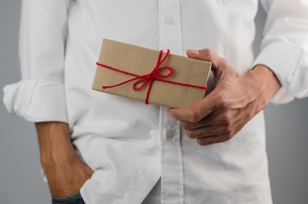 Mão segurando uma caixa de presente, caixa de presente de ano novo, caixa de presente de Natal, espaço de cópia. Natal, ano de vida, conceito de aniversário.