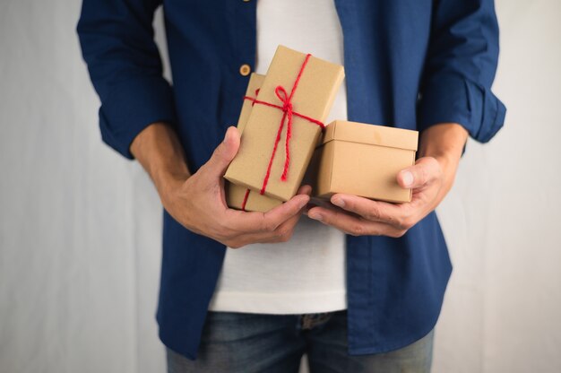 Mão segurando uma caixa de presente, caixa de presente de ano novo, caixa de presente de Natal, espaço de cópia. Natal, ano de vida, conceito de aniversário.