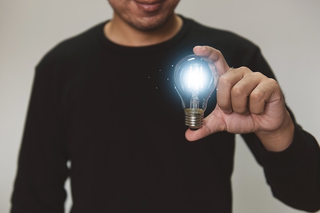 Mão segurando uma ideia de lâmpada com inovação e inspiração