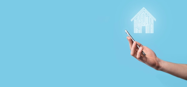 Mão segure o ícone da casaCasa inteligente controlada por casa inteligente e conceito de aplicativo de automação residencialProjeto de pcb e pessoa com telefone inteligente Tecnologia de inovação conceito de rede de internet