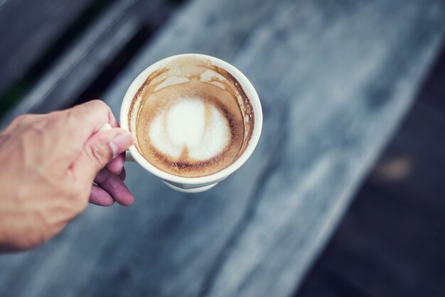 Mão segure uma xícara de café