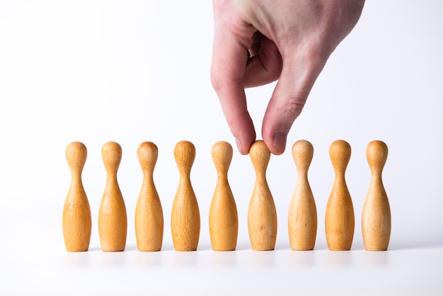 Mão selecionando uma figura de madeira Conceito de liderança empresarial