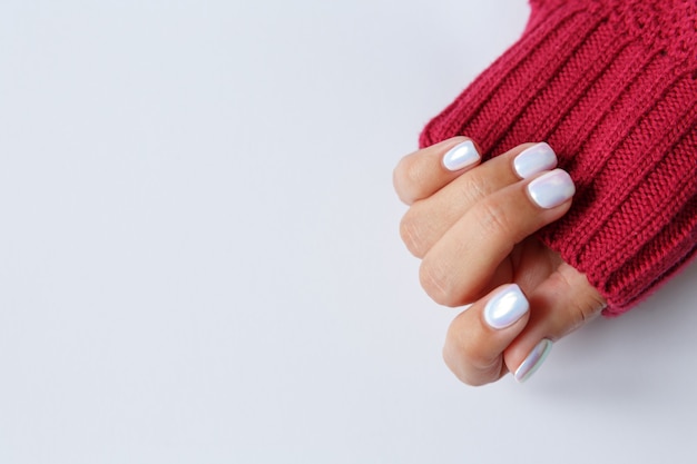 Mão sobre um fundo branco e uma bela manicure