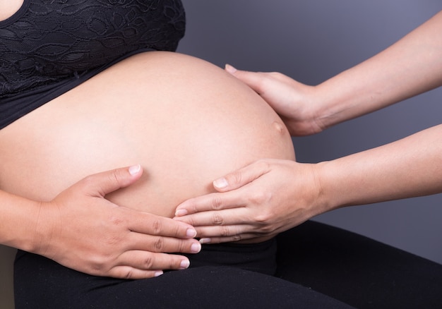 mão tocando a barriga da mulher grávida