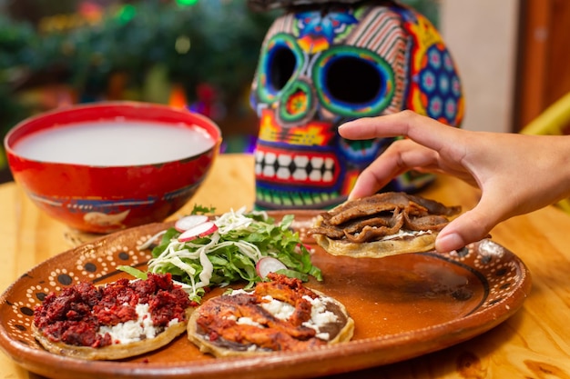 mão tomando sopas de carne mexicana da tradicional oferta de dia de muertos