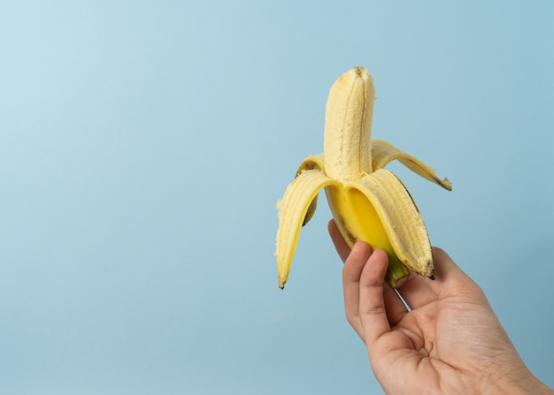 Mão um homem segura banana com um espaço de cópia.