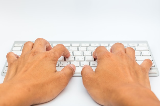 Foto mão usando o teclado do computador em branco isolado