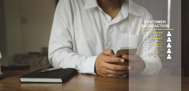 Mão usando telefone celular para feedback de classificação de serviço da pesquisa de experiência do cliente