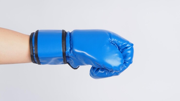 Foto mão usar luvas de boxe azuis em fundo branco