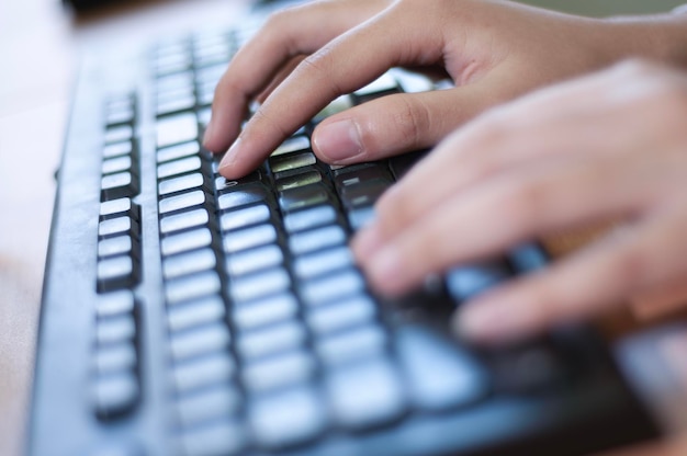 Foto mãos a digitar num teclado de computador