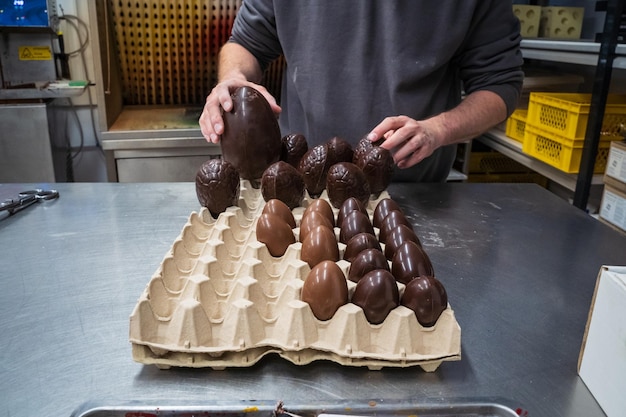 Mãos colocando ovos de chocolate