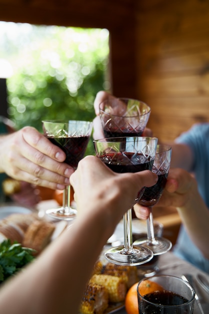 Mãos com bebidas em copos celebram festa campo