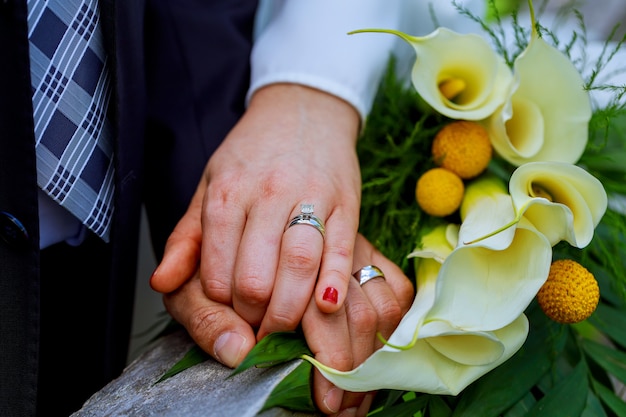 Mãos, com, casamento, anéis ouro, feliz, newlyweds, e, buquê, flores, kala