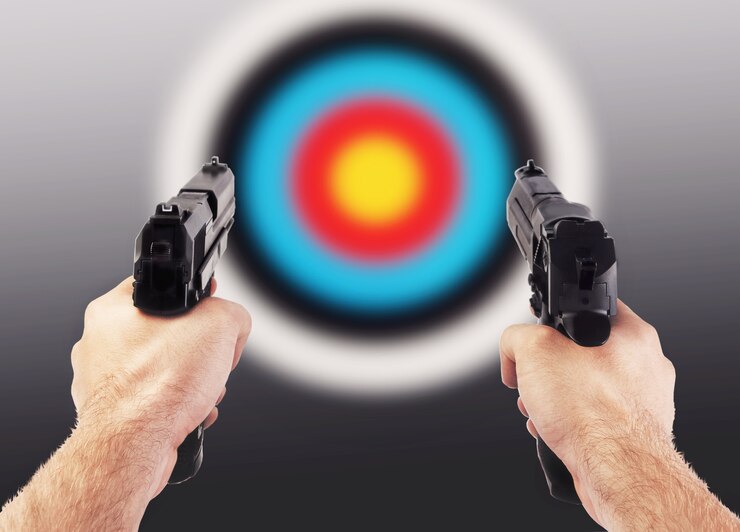 Foto mãos com duas armas contra um alvo de tiro colorido