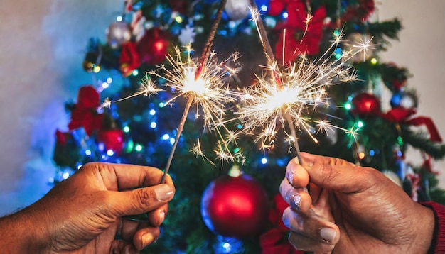 mãos com faíscas brilhantes e detalhes e decoração de natal de fundo